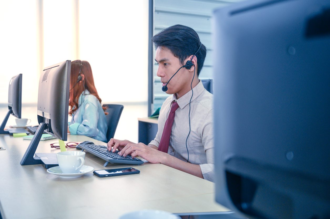 man sitting at computer with headset