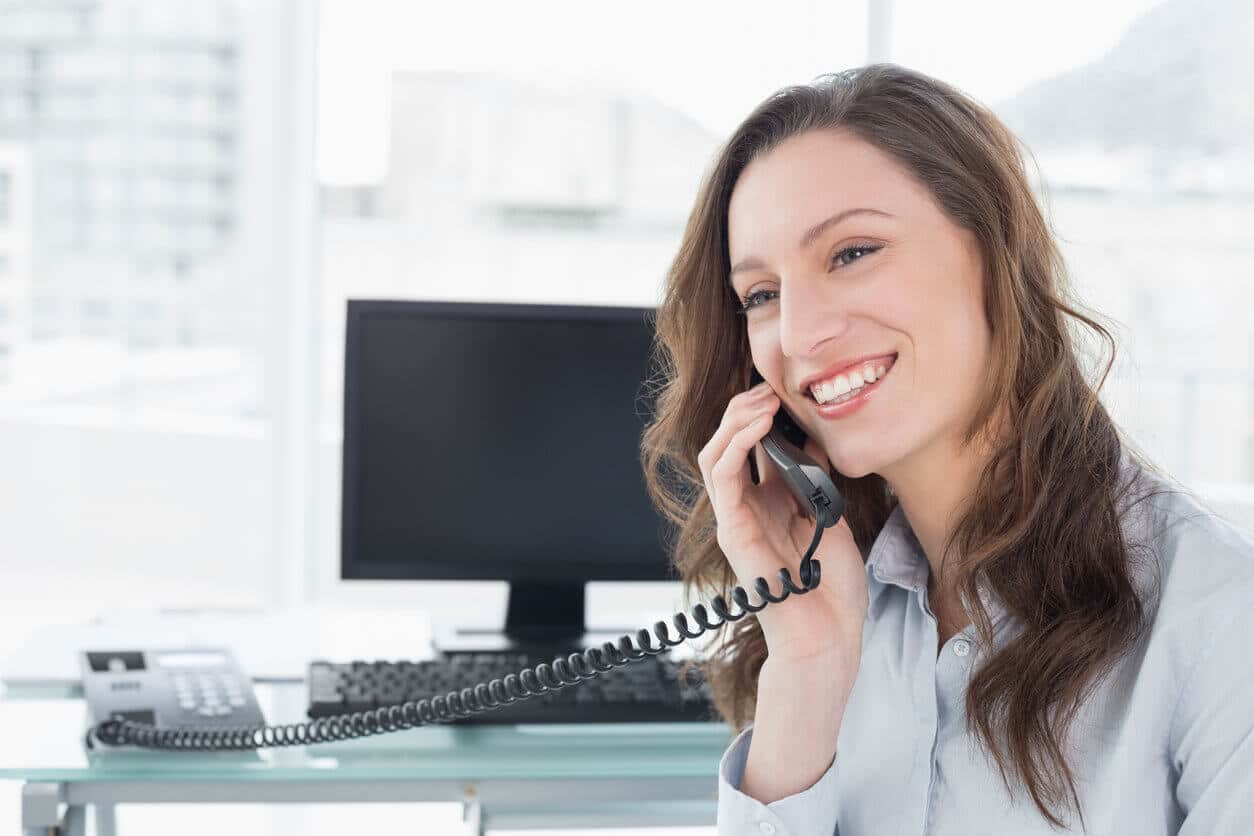 female on phone call in front of computer