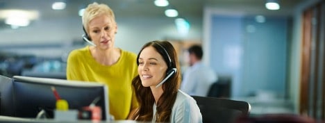 female customer service agent and female supervisor listening empathetically to a customer while sitting at a desk female customer service agent and female supervisor listening empathetically to a customer while sitting at a desk