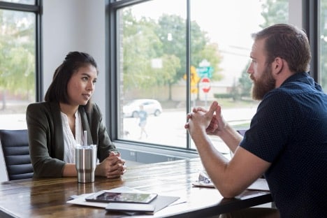 female professional sitting at a desk discussing a complaint with a customer female professional sitting at a desk discussing a complaint with a customer