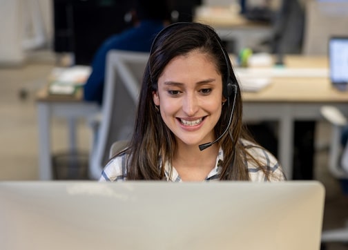 a USA call center agent wearing a headset in front of a computer