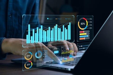 A person’s hands seen typing on a laptop, generating pie charts, graphs, and other analytical tools. A person’s hands seen typing on a laptop, generating pie charts, graphs, and other analytical tools.