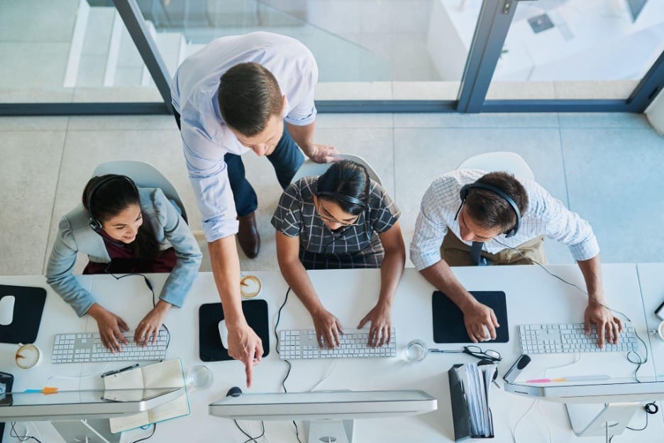 A call center supervisor helps three agents to develop skills for inbound and outbound calls. A call center supervisor helps three agents to develop skills for inbound and outbound calls.