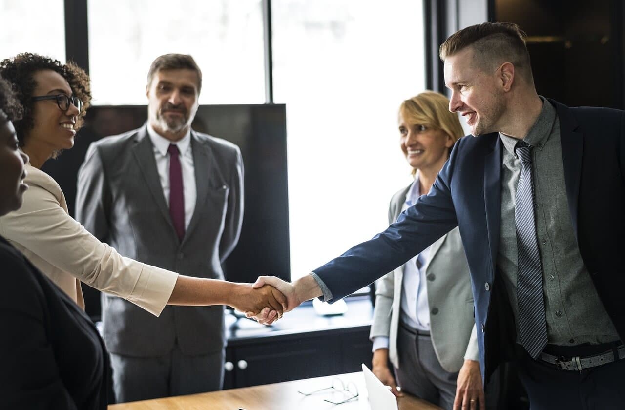colleagues shaking hands after discussing the benefits of customer support outsourcing