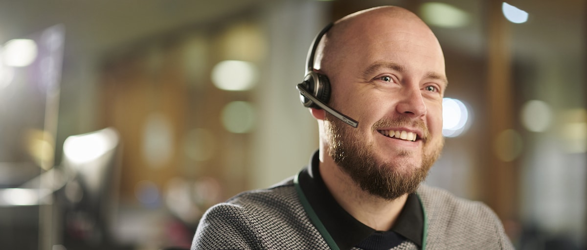 someone sitting at their desk wearing a headset discussing ways to avoid call center turnover