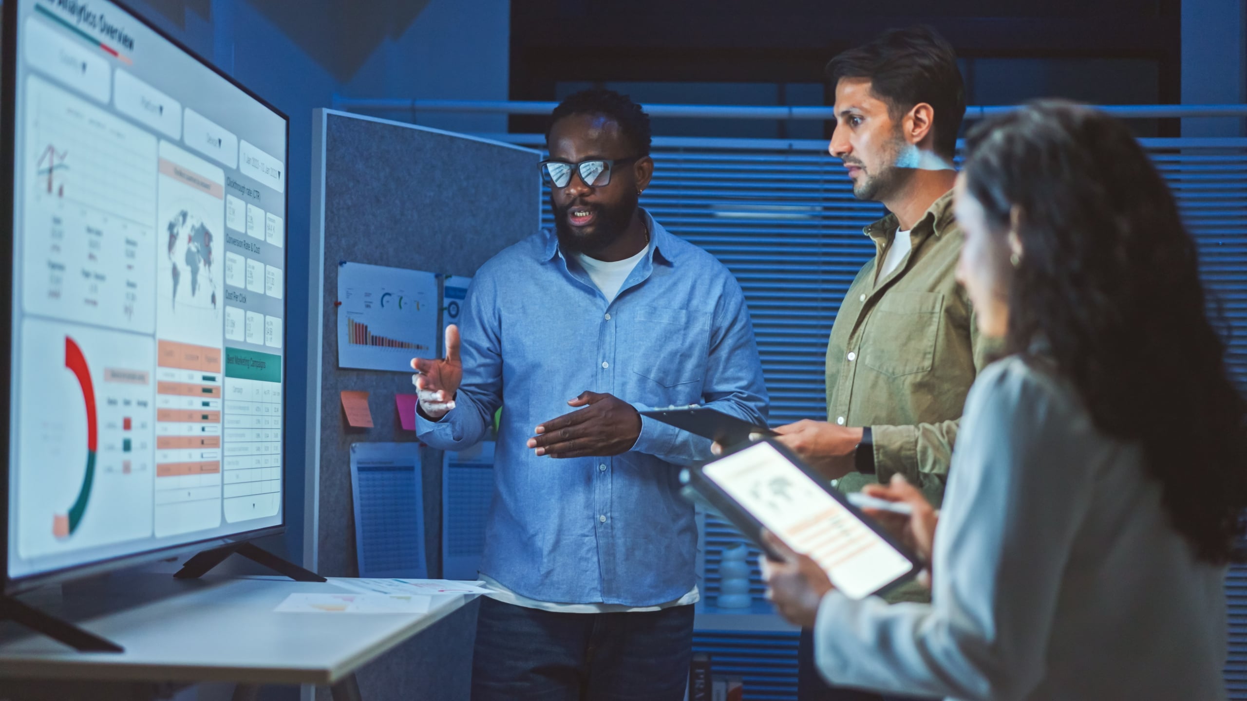 A team of agents discussing a screen full of data.