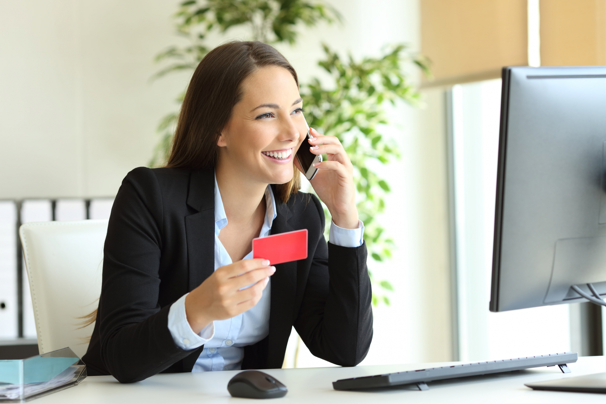 Happy businesswoman on the phone while buying with credit card