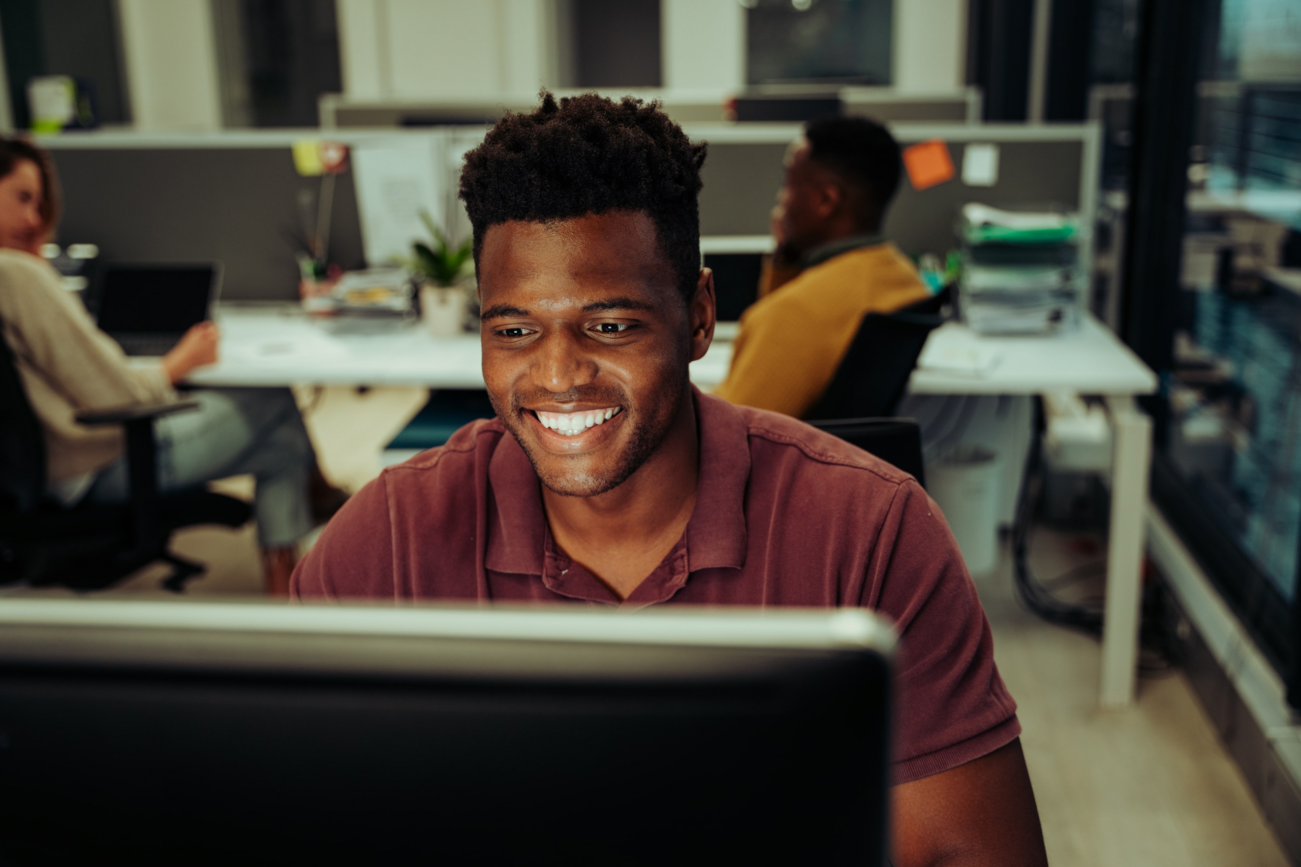 African american salesperson smiling at his computer