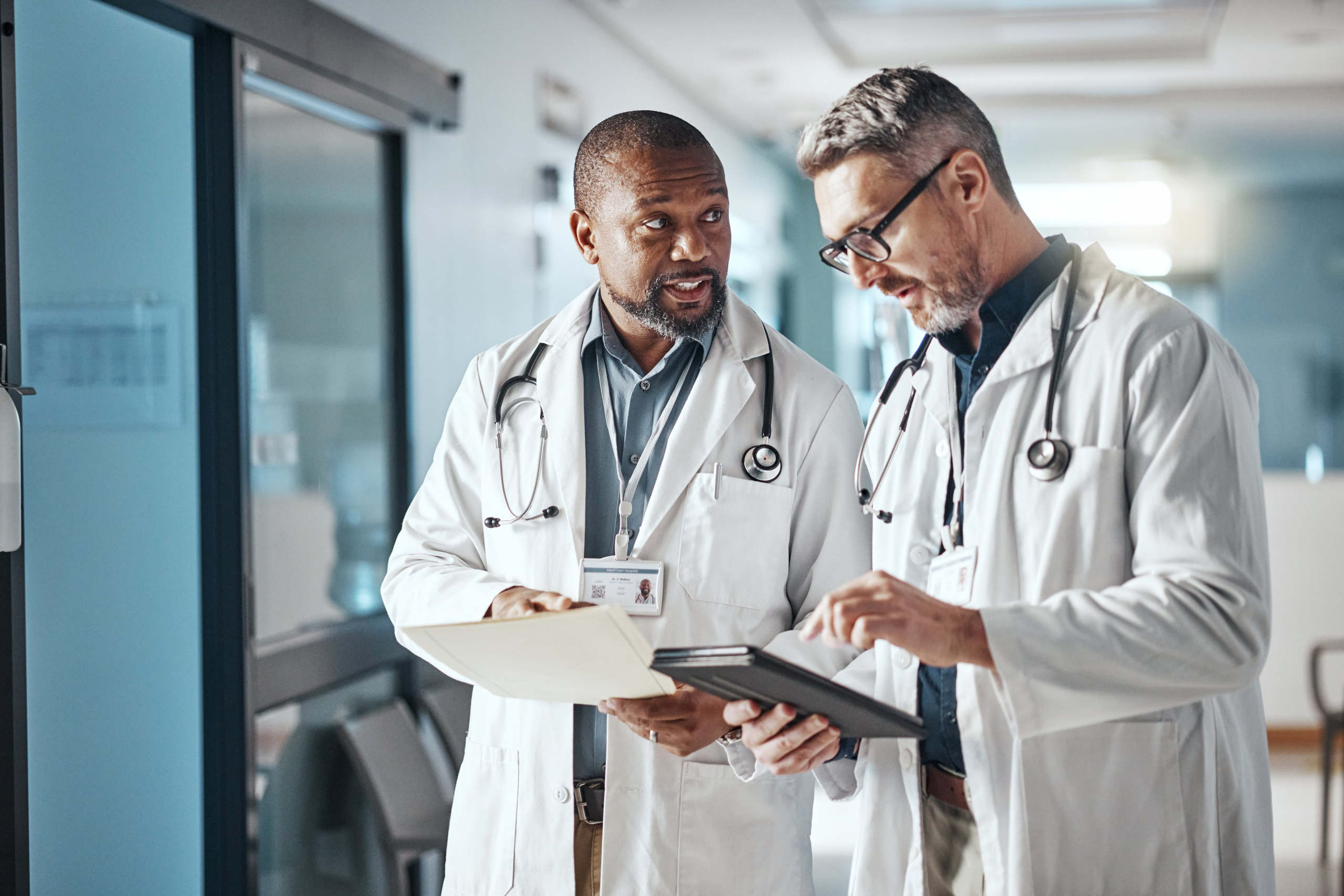 2 male doctors looking at reports and talking