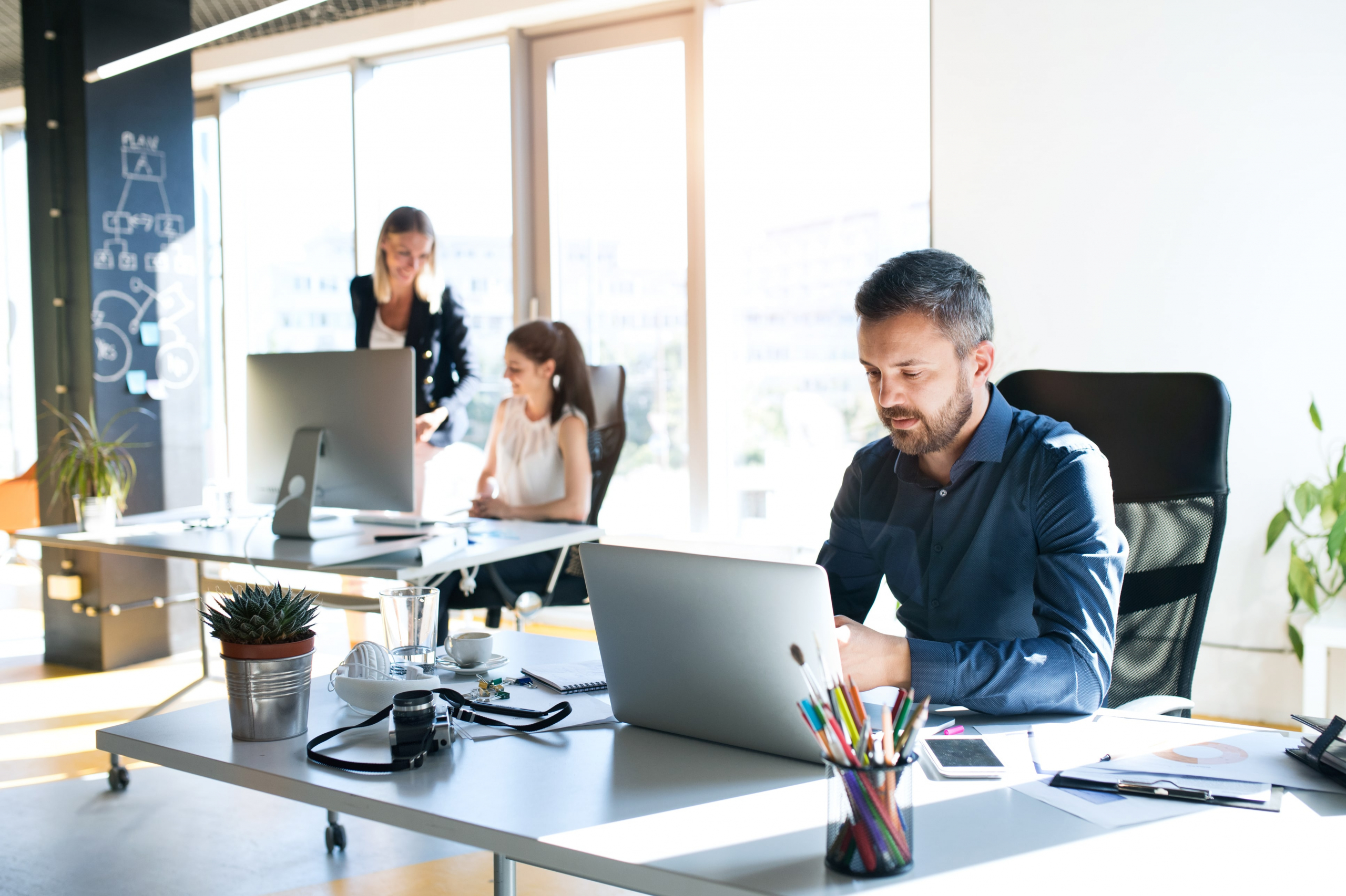 2 Co-workers in a modern office working at their computers